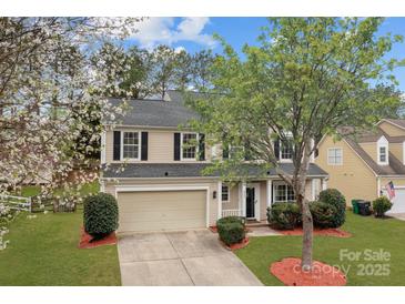 Charming two-story home with a well-maintained lawn, mature trees, and a two-car garage at 8932 Raven Park Dr, Charlotte, NC 28216