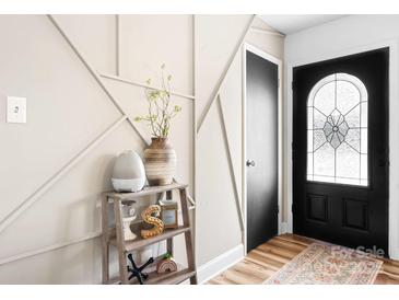 Stylish entryway featuring decorative wall trim, hardwood floors, and a black front door with glass detailing at 104 Pop Davis Rd, Taylorsville, NC 28681