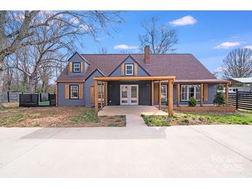 Charming home featuring dark gray siding, a brown roof, an inviting front entry and tidy landscaping at 1200 Grace Ave, Kannapolis, NC 28083