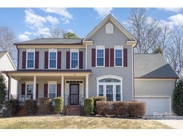 Charming two-story home with gray siding, red shutters, and a welcoming front porch at 158 Crimson Orchard Dr, Mooresville, NC 28115