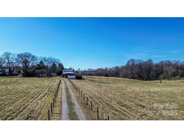Expansive land featuring a dirt driveway leading up to a barn with plenty of room for activities at 169 Eagle Mills Rd, Harmony, NC 28634