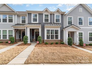 Charming townhome featuring gray siding, white trim, well-kept landscaping and a welcoming front entrance at 2130 Blewett Dr, Charlotte, NC 28269