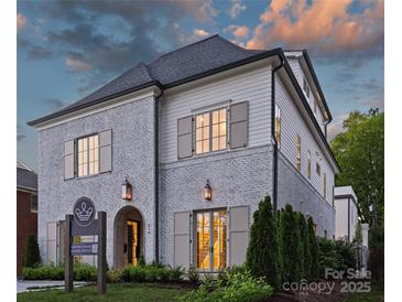 Elegant two-story home featuring a blend of white brick and siding, accentuated by dark roof and shutter details at 238 Laurel S Ave # B, Charlotte, NC 28207