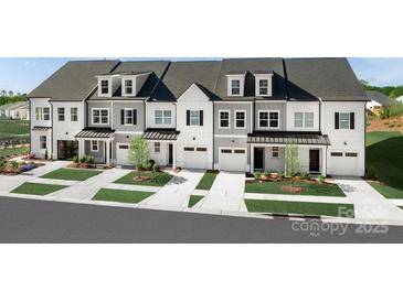 A row of new townhomes featuring varied facade colors, individual garages, and professionally landscaped front yards at 3051 Finchborough Ct # 219, Charlotte, NC 28269