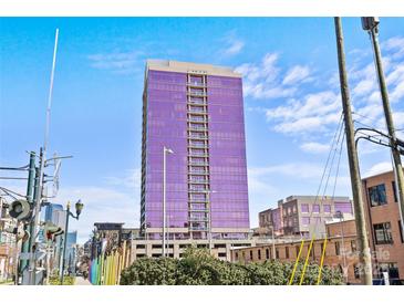 Modern high-rise building featuring purple glass facade with balcony and an urban setting, with a vibrant, sunny backdrop at 315 Arlington Ave # 1206, Charlotte, NC 28203