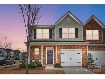 Charming townhome exterior featuring a well-maintained lawn and a welcoming front entrance with a wreath at 3925 Rothwood Ln, Harrisburg, NC 28075