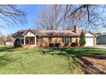 Charming single-story brick home with a well-manicured lawn and mature trees in a peaceful neighborhood at 7770 Sherrills Ford Rd, Sherrills Ford, NC 28673