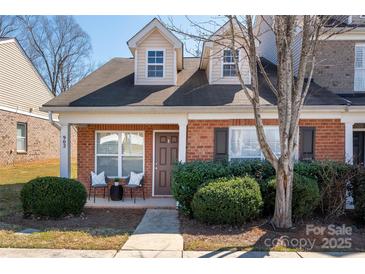 Charming brick townhouse with a covered front porch, cozy seating, and well-maintained landscaping at 902 Tj Dr # 15, Monroe, NC 28112