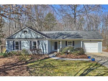 Charming single story home with light siding, complemented by a well-manicured lawn and mature trees at 9505 Kent Village Dr, Charlotte, NC 28269