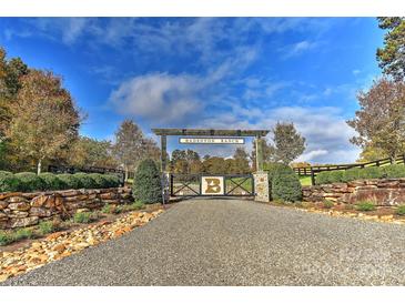 Badenyon Ranch entrance featuring stone walls, wood gates, and gravel drive under a blue sky at 153 Badenyon Pl, Union Grove, NC 28689