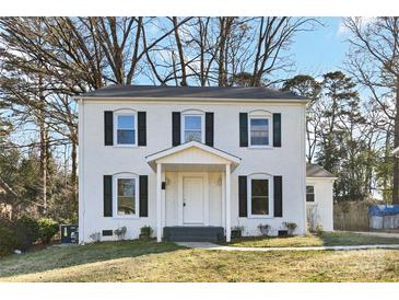 Charming two-story home featuring a white brick facade, black shutters, and a welcoming front porch at 5717 Ruth Dr, Charlotte, NC 28215