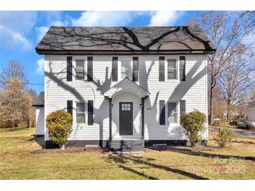 Charming two-story home featuring a gray roof, a black door and shutters, and a well-maintained front lawn at 606 N Elm St, Marshville, NC 28103