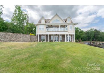 Beautiful lakefront home featuring a large lawn and multiple outdoor spaces at 627 Birdie Ln # 21/22, Norwood, NC 28128