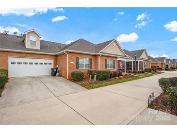 Brick home showcasing a two-car garage, well-maintained lawn, and inviting curb appeal at 8439 Sonata Ct, Denver, NC 28037