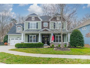 Charming two-story home with a covered front porch, lush landscaping, and a well-maintained lawn at 1122 Saratoga Blvd, Indian Trail, NC 28079