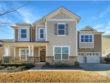 Charming two-story home features stone accents, a covered porch, and an attached two-car garage at 12326 Cranberry Glades Dr, Cornelius, NC 28031