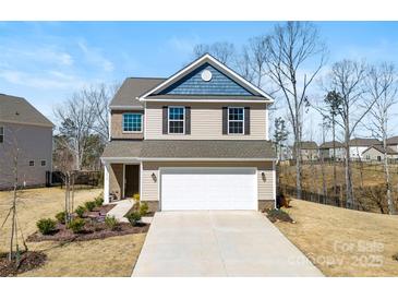 Charming two-story home features a well-manicured front yard, attached two-car garage, and inviting curb appeal at 14030 Turncloak Dr, Charlotte, NC 28278