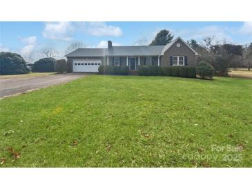 Charming brick home with attached garage, manicured hedges, and a lush green front yard at 189 Beech Brook Ln, Statesville, NC 28625