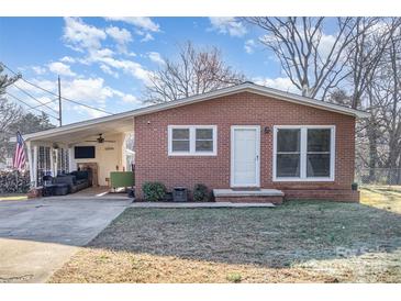 Charming brick ranch home with covered carport featuring outdoor seating and well-maintained yard at 2320 Monterey Park Dr, Gastonia, NC 28054