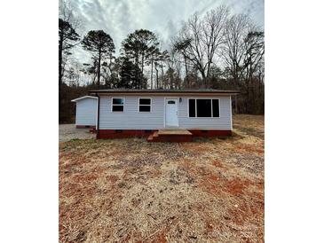 Charming single-story home featuring light gray siding, a red brick foundation and a well-manicured yard at 3437 Wilkesboro Hwy, Statesville, NC 28625
