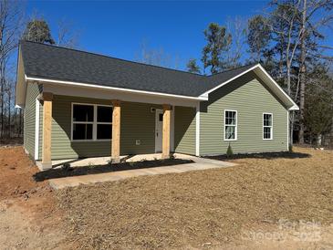 Charming single-story home with light green siding, stone accents, and a well-manicured lawn at 3537 Taxahaw Rd, Lancaster, SC 29720