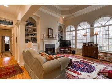 Bright living room featuring large arched windows, fireplace, built-in shelving, and decorative rug at 423 Bethel Dr, Salisbury, NC 28144