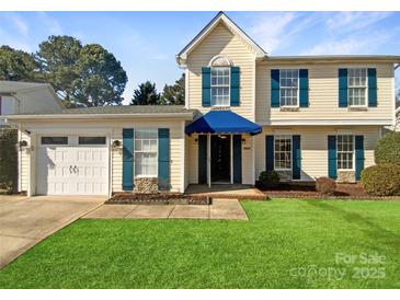 Charming two-story home featuring blue shutters, a manicured lawn, and a two-car garage at 6606 Antrim Ct, Charlotte, NC 28217