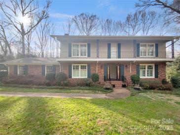 Charming two-story brick home with second story covered patio and lush front yard at 6813 Linda Lake Dr, Charlotte, NC 28215