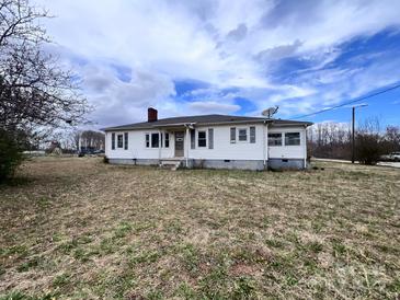 Quaint one-story home with white siding, a chimney, and a spacious front yard at 930 Weaver Rd, China Grove, NC 28023