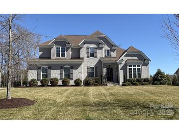 Stunning two-story brick home with a manicured lawn and beautiful landscaping, showcasing its curb appeal at 1005 Cherry Laurel Dr, Waxhaw, NC 28173