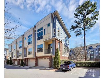 Modern townhome featuring a 1-car garage, brick facade, and blue and cream exterior paint at 1037 Pierre Dr, Charlotte, NC 28205