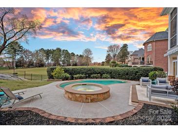 Inviting backyard pool and spa area with an outdoor seating area, perfect for relaxation and entertaining guests at 13500 Robert Walker Dr, Davidson, NC 28036