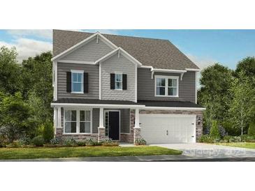 Charming two-story home featuring gray siding, a covered porch, an attached garage, and well-maintained landscaping at 136 Glenn Dr, Mooresville, NC 28115