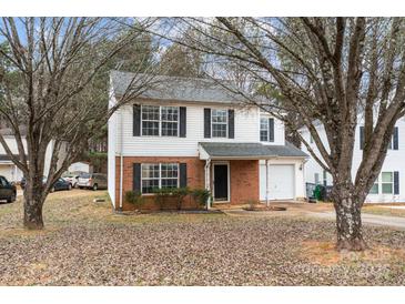 Charming two-story home with a brick and siding exterior, complemented by lush landscaping at 303 Cupped Oak Ct, Charlotte, NC 28213