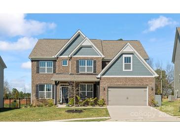 Charming two-story brick home with a well-manicured lawn and attached two car garage at 5585 Zeeland Ln, Fort Mill, SC 29707