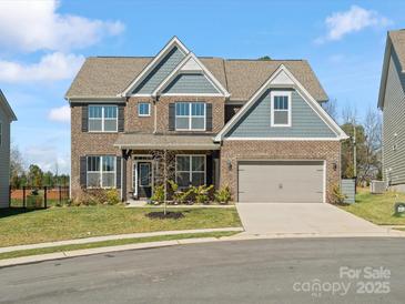 Charming two-story home with a brick facade, covered entrance, two-car garage, and well-maintained lawn at 5585 Zeeland Ln, Fort Mill, SC 29707