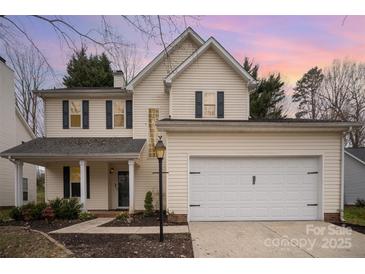 Two-story home with vinyl siding, black shutters, attached garage, and manicured landscaping at 6027 Edinmeadow Ln # 29, Charlotte, NC 28269