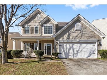 Charming two-story home featuring a welcoming front porch and a two-car garage with well-maintained landscaping at 7003 Dacian Ln, Indian Trail, NC 28079