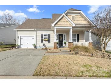 Charming single Gathering home with a well maintained lawn and inviting covered porch at 8409 Backer Ln, Fort Mill, SC 29707