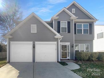 Traditional two-story home featuring gray siding, a two-car garage and manicured landscaping at 9139 Hearst Ct, Charlotte, NC 28269