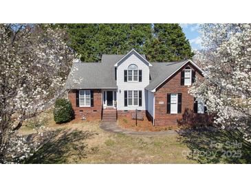 Charming two-story home with brick and white siding, black shutters, and mature trees in a landscaped yard at 919 42Nd Avenue Ne Ln, Hickory, NC 28601