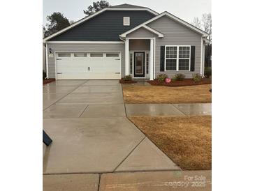 Charming one-story home featuring a gray exterior, a two-car garage, and a manicured front yard at 1429 Nia Rd, Charlotte, NC 28215