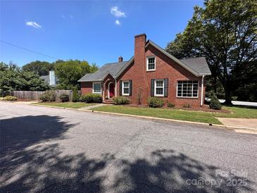 Charming red brick home with a well-manicured lawn and a classic red front door at 115 6Th Ne Ave, Hickory, NC 28601
