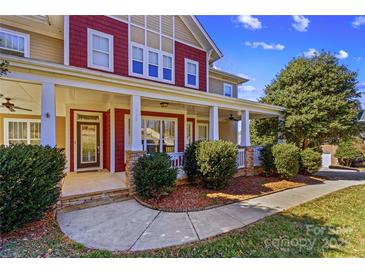Inviting home featuring a charming front porch with stone accents and manicured landscaping at 137 Hunters Hill Dr, Statesville, NC 28677