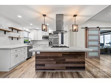 Bright kitchen features stylish island, modern appliances, and floating shelves at 1536 Plyler Lake Rd, Gastonia, NC 28054