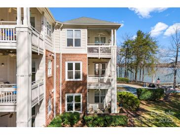 Lakefront condo featuring balconies, brick accents, and lush landscaping with beautiful lake views at 921 Northeast Dr # 26, Davidson, NC 28036