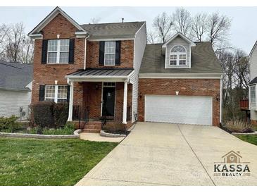 Charming two-story brick home featuring an attached two-car garage and manicured front yard at 1004 Canopy Dr, Indian Trail, NC 28079