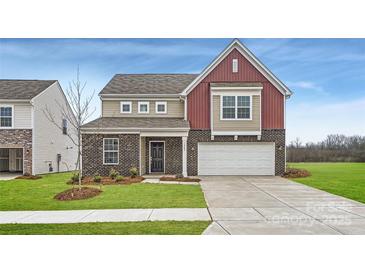 Two-story home featuring a brick facade, two-car garage, and a well-manicured lawn at 1402 Pine Heart Dr, Edgemoor, SC 29712