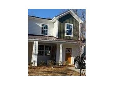 Charming home with a blend of white and green board and batten siding, and covered entryway at 1518 Norris Ave, Charlotte, NC 28206