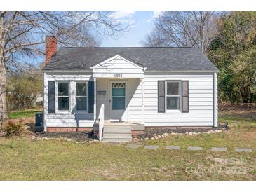 Charming one-story home featuring a brick chimney, symmetrical black shutters, and manicured landscaping at 1911 Woodlawn St, Kannapolis, NC 28083